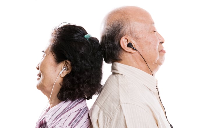 Senior asian couple listening to music