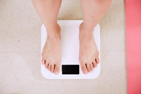 woman measuring her weight on a scale